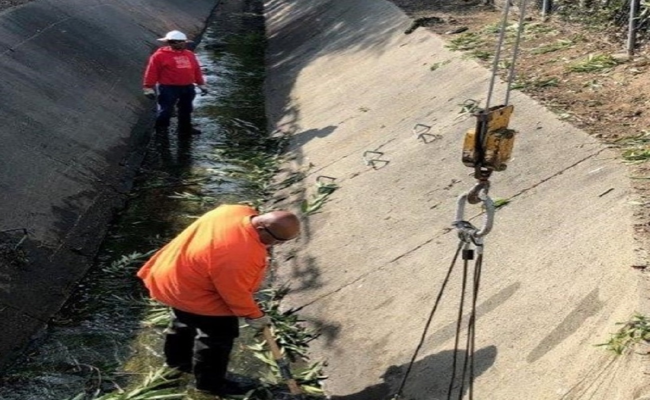 Workers maintaining flood control channels