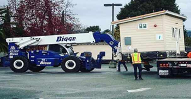 workers moving a small building