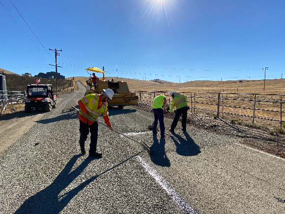 workers chip sealing road