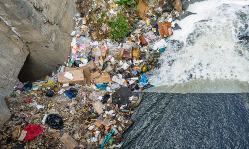 trash strewn on creekbank