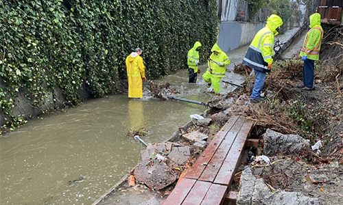 Rain crew clearing debris in flooded channel